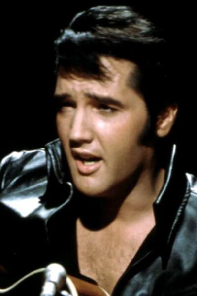 imagen del cantante en sus inicios, cantando y sujetando una guitarra