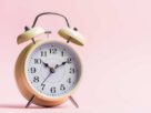 reloj en fondo rosa