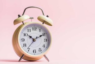 reloj en fondo rosa