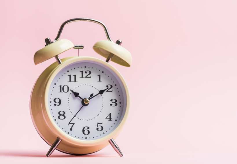 reloj en fondo rosa